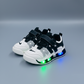 Baskets lumineuses LED pour enfants, disponibles en quatre coloris, avec empiècements en mesh respirant, brides auto-agrippantes et semelles transparentes qui s'illuminent en marchant.